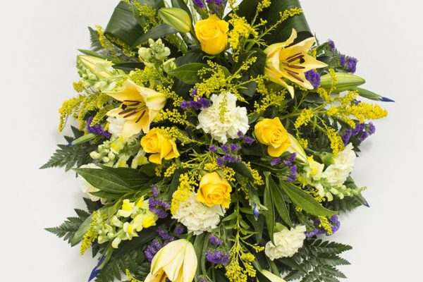 An arrangement of Lilies, Roses, Stocks, Solidagos and Carnations highlighted with Blue Status and set against a backdrop of fresh greenery. From €120.