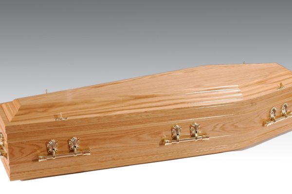 Oak veneered coffin with profiled features to coffin sides, fitted with plastic handles and a standard interior.